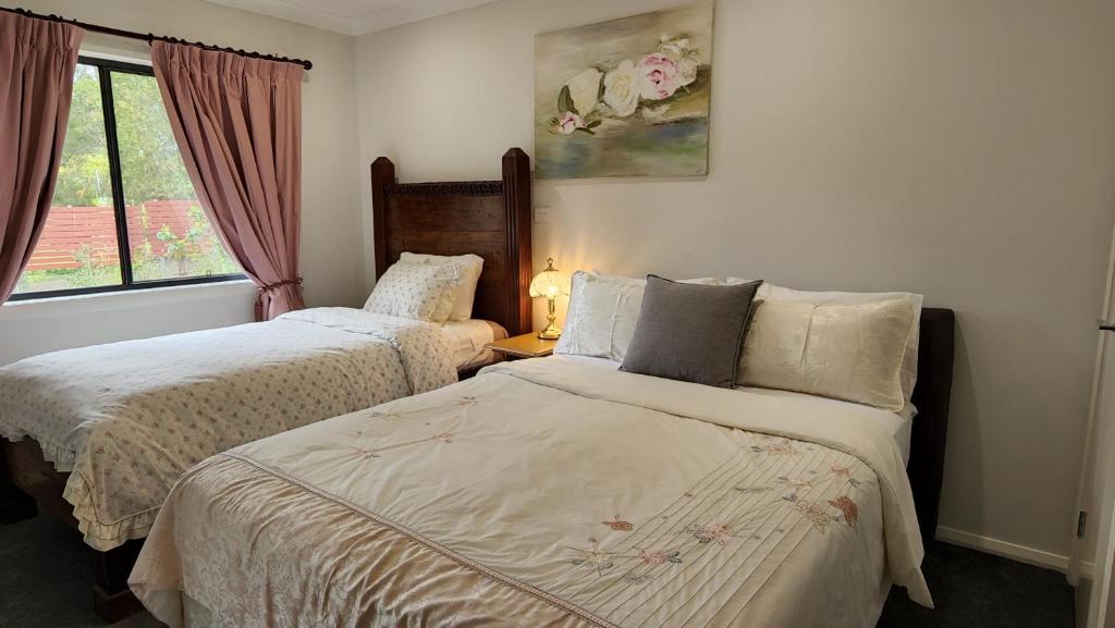 una camera da letto con due letti e una finestra di Gowrie Agapanthus a Singleton