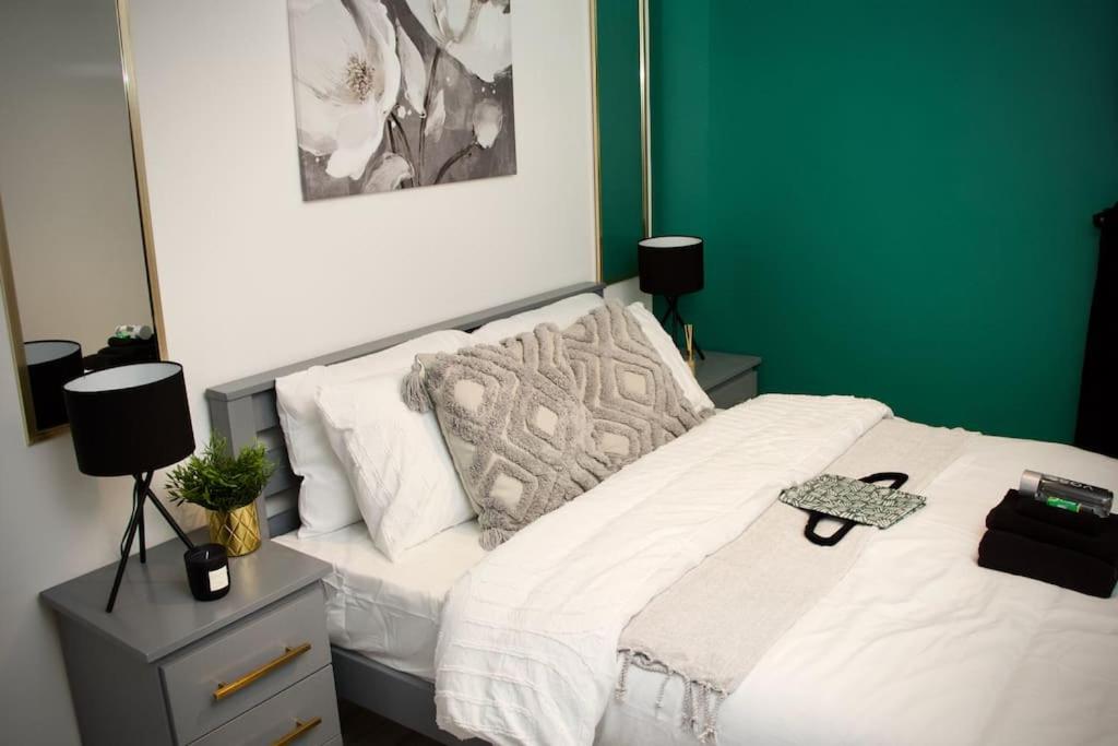 um quarto com uma cama branca e uma parede verde em 1 Bed Apartment B em Birmingham