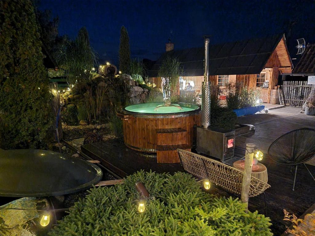 - un jardin avec un bain à remous dans une cour la nuit dans l'établissement Oaza Mazurska - Domek z kominkiem, à Piecki