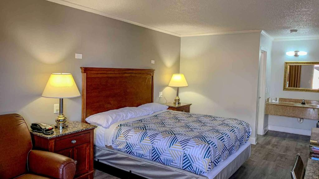 ein Schlafzimmer mit einem Bett, einem Waschbecken und zwei Lampen in der Unterkunft Motel 6 Newport News, VA – Fort Eustis in Newport News