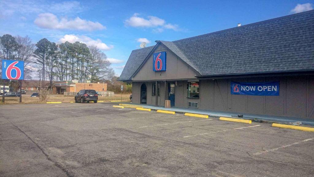 a parking lot in front of a now open store at Motel 6 Newport News, VA – Fort Eustis in Newport News