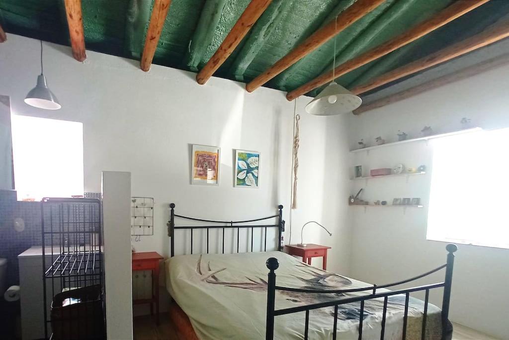 a bedroom with a black bed in a room at El Charcón in Higuera de la Sierra