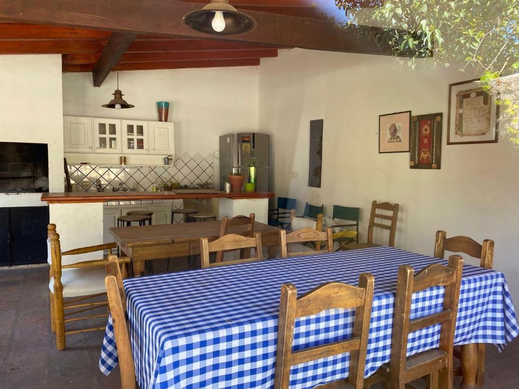 a dining room with a table and chairs and a kitchen at Posada de la Montaña in La Cumbre