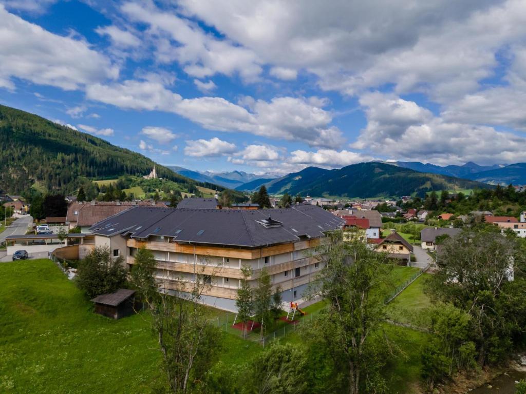 a building on a hill with mountains in the background at Lungau Residence Top 0-6 in Tamsweg