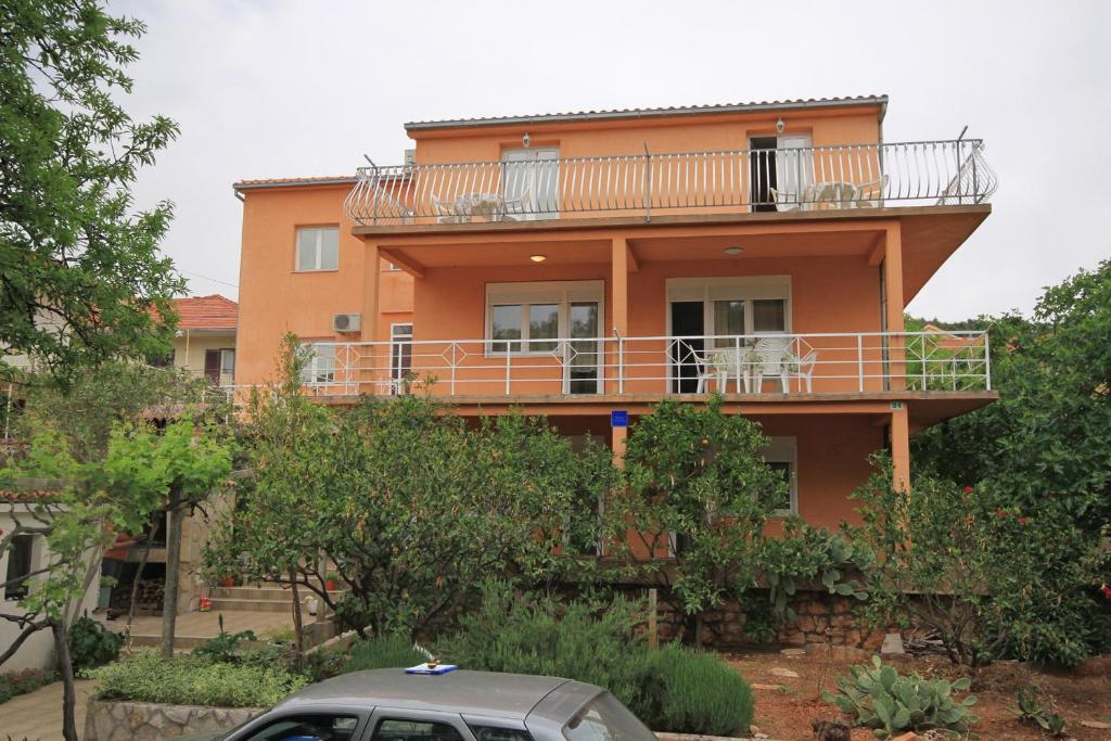 een huis met een balkon en een auto voor de deur bij Apartments with a parking space Stari Grad, Hvar - 8757 in Stari Grad