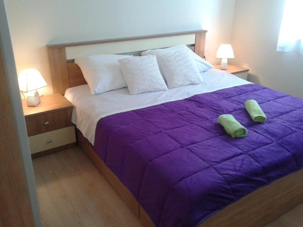 a bedroom with a purple bed with two pillows on it at 4 bedroom apartment with 3 bathrooms and private parking - Apartments Orange in Zadar