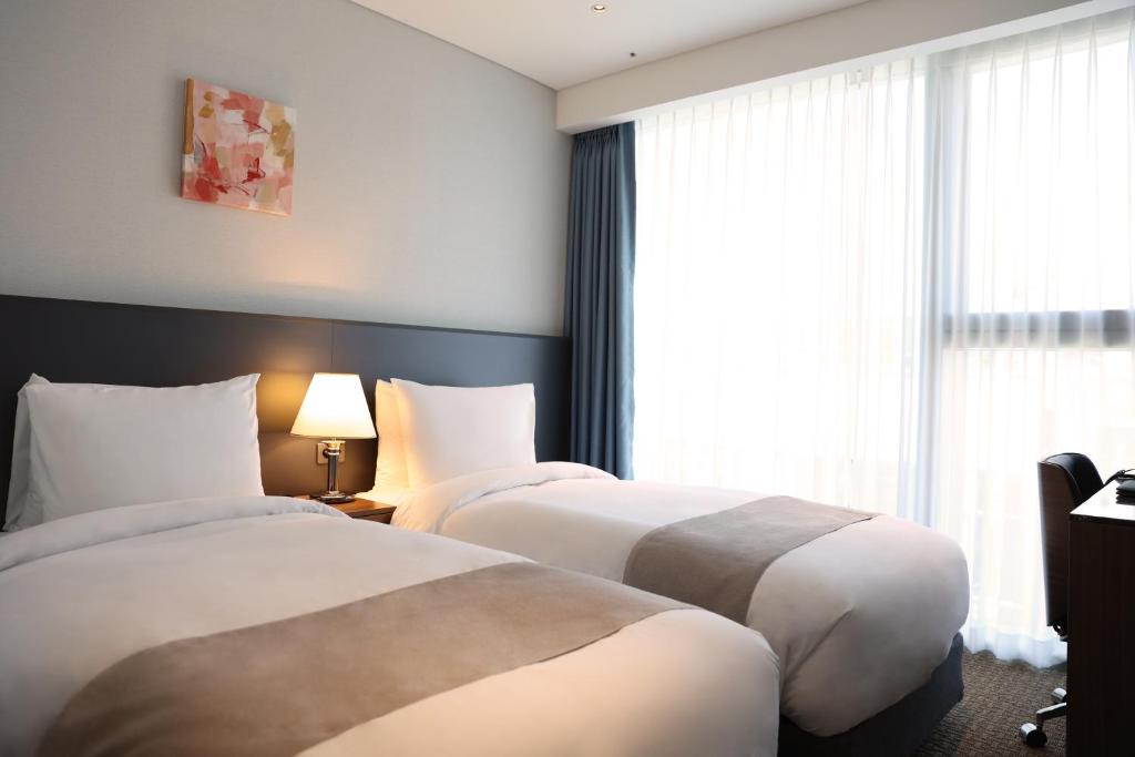 Postel nebo postele na pokoji v ubytování Stanford Hotel Myeongdong