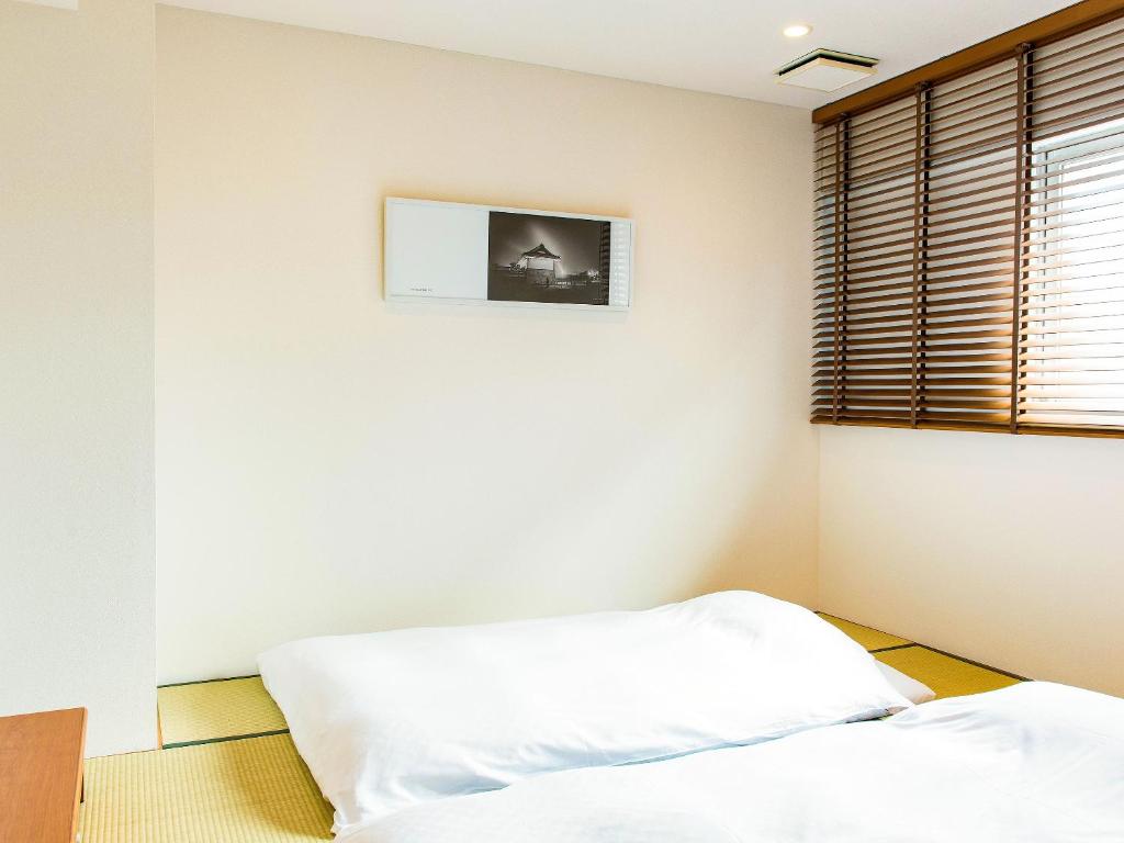 a bedroom with a bed and a picture on the wall at Hotel Pacific Kanazawa in Kanazawa