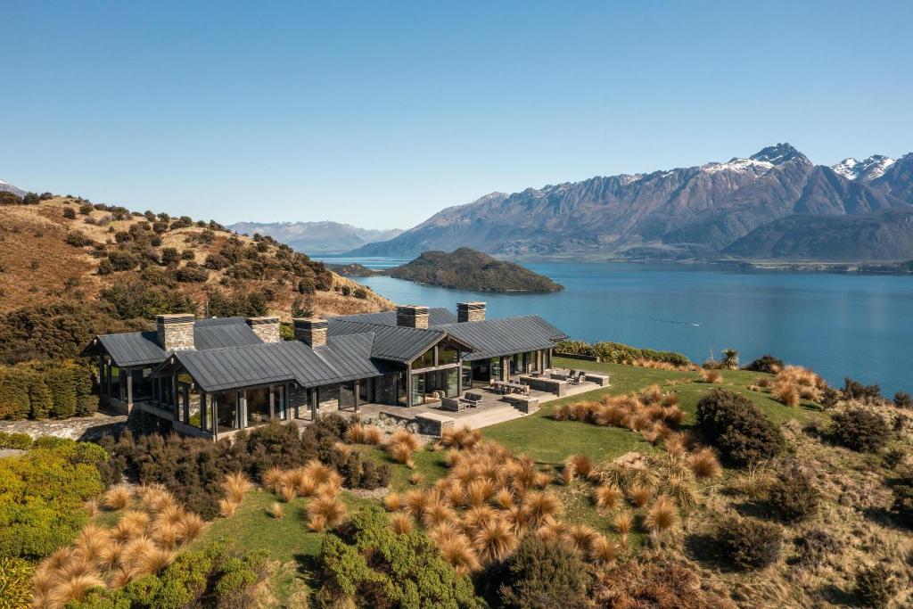 an aerial view of a house on a hill next to a lake at Lodge Lorien in Glenorchy