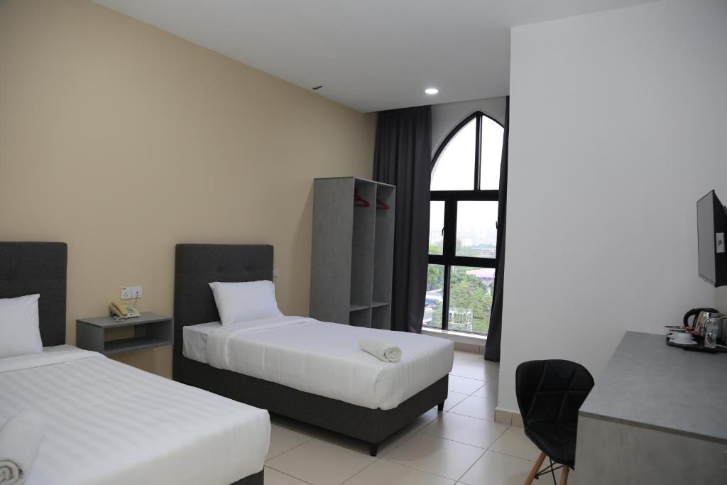 a hotel room with two beds and a window at Pusat Belia Antarabangsa in Kuala Lumpur