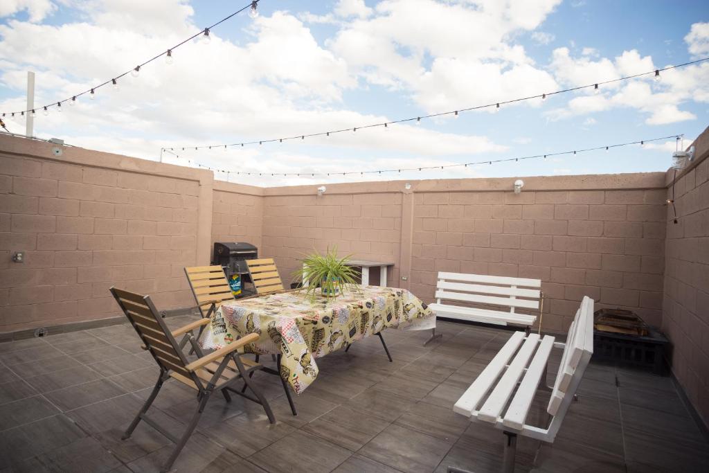 eine Terrasse mit einem Tisch, Stühlen und einem Zaun in der Unterkunft Casa Genova, casa amplia y comoda, terraza privada in Ciudad Juárez