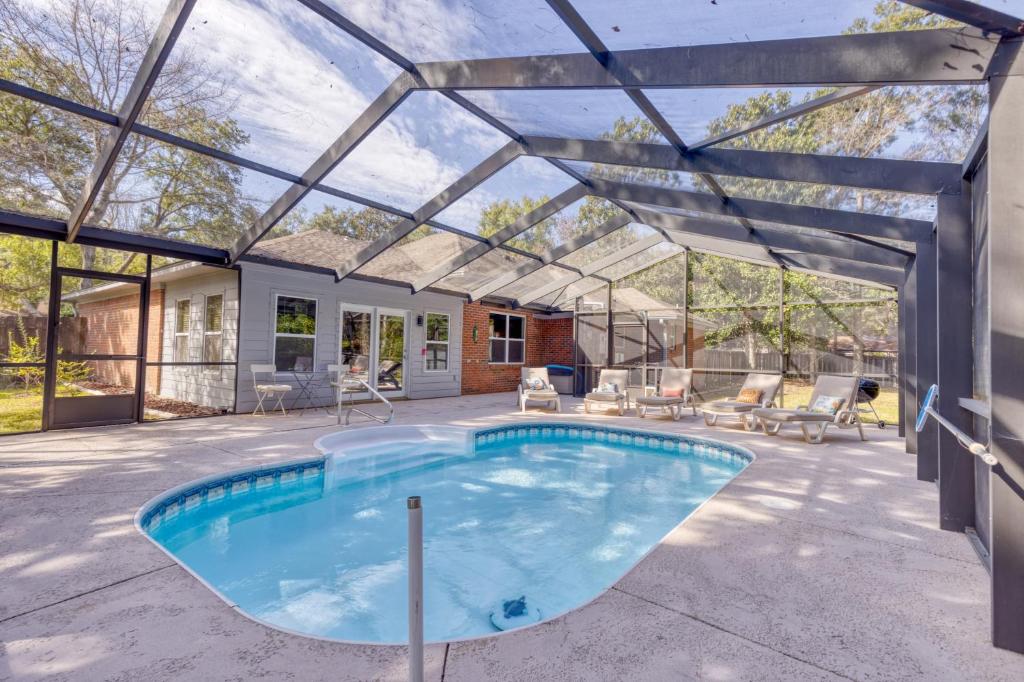 a swimming pool with a pergola and a house at Blissful Beach Retreat with Screened-in Pool in Ocean Springs