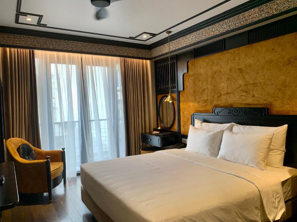 a bedroom with a large bed and a window at Hotel du Monde Classic in Hanoi