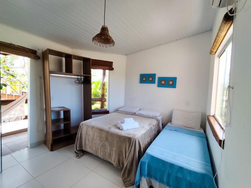 a bedroom with two beds and a window at Pousada dos Cardeais in Barra Grande