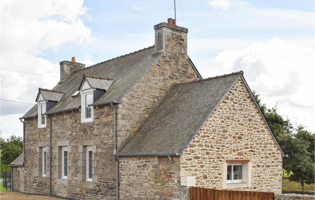 an old stone house with a black roof at 2 Bedroom Amazing Home In Brlidy in Brélidy