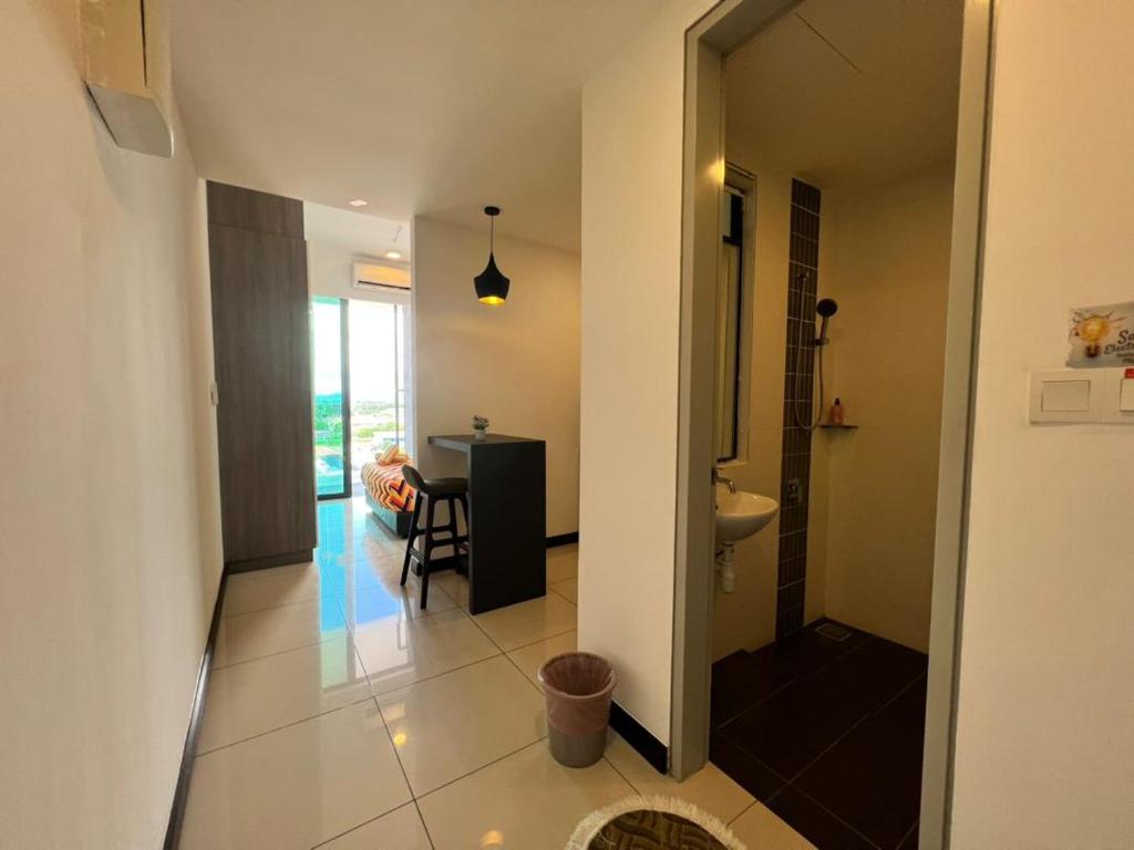 a hallway with a bathroom with a sink and a table at Private Condo Port Dickson Waterfront in Port Dickson