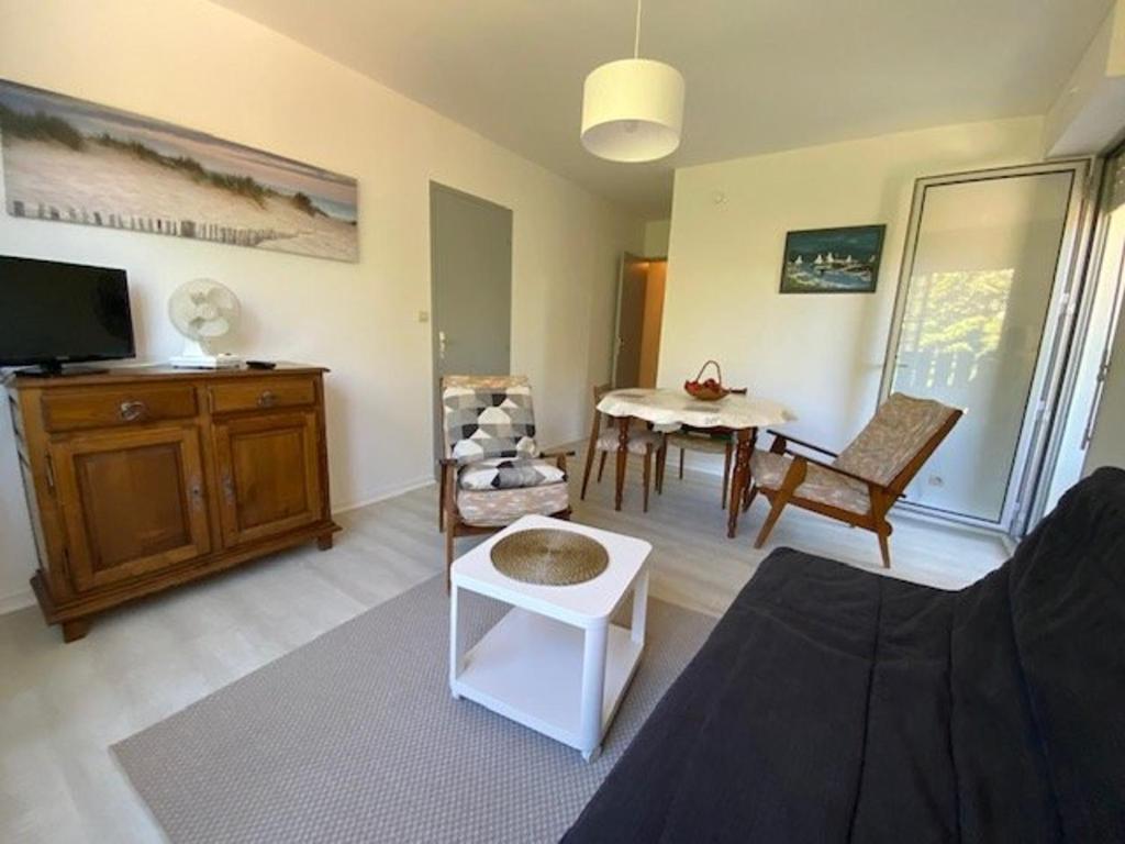 un salon avec un canapé, une table et une télévision dans l'établissement Appartement T2 rénové pour 4 pers, au pied de la plage avec 2 balcons et parking privé, St Georges - FR-1-494-135, à Saint-Georges-de-Didonne