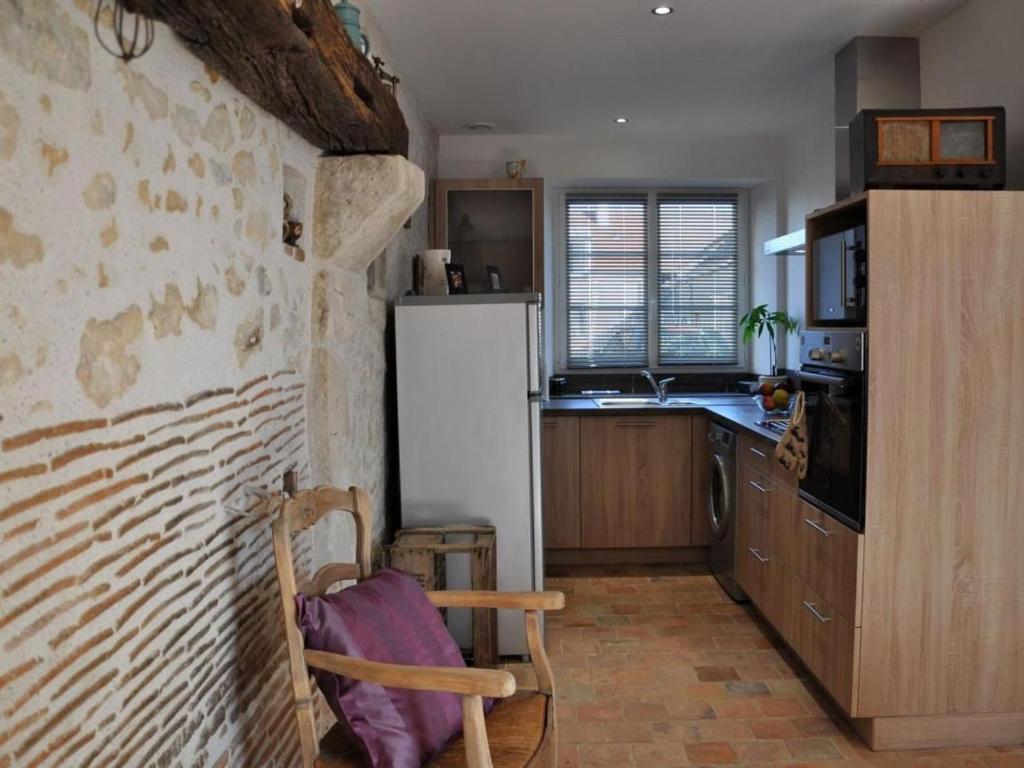 a kitchen with a refrigerator and a chair in it at Charmante maison près des châteaux de la Loire avec jardin fermé et animaux bienvenus - FR-1-590-65 in Saint-Hilaire-Saint-Mesmin