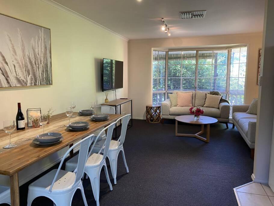 - un salon avec une grande table et des chaises dans l'établissement Yarra House - Comfortable 3 bedroom home close to everything!, à Healesville
