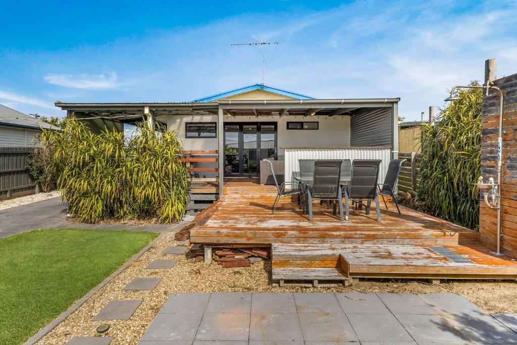 a backyard with a wooden deck with chairs and a table at Alumuna in Cape Woolamai in Cape Woolamai