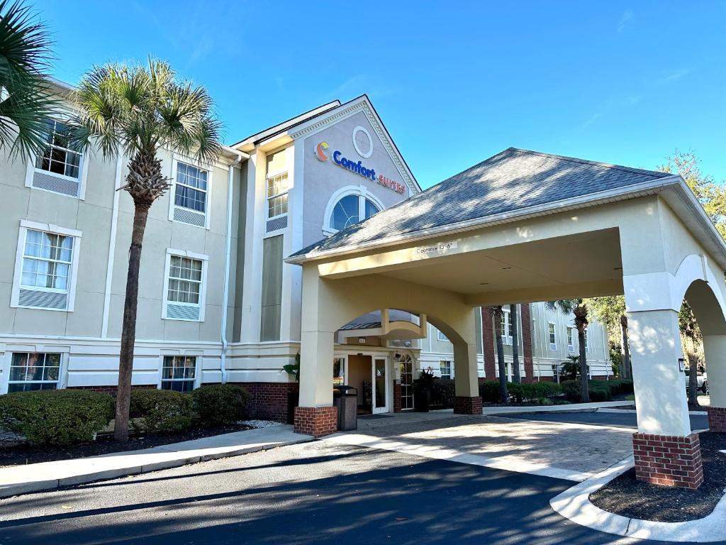 a hotel with a building and a palm tree at Comfort Suites Bluffton-Hilton Head Island in Bluffton
