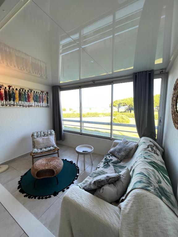 une chambre avec un lit, une chaise et une fenêtre dans l'établissement Le Studio de la Lagune studio cabine proche de la plage, au Grau-du-Roi