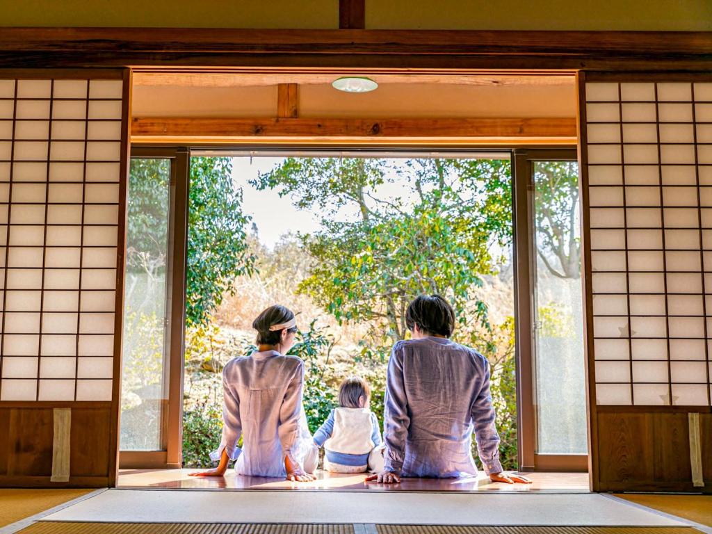 美作市にあるIrori no oyado zen - Vacation STAY 80209vの大人2名と子供1名(ドアを外に見る)