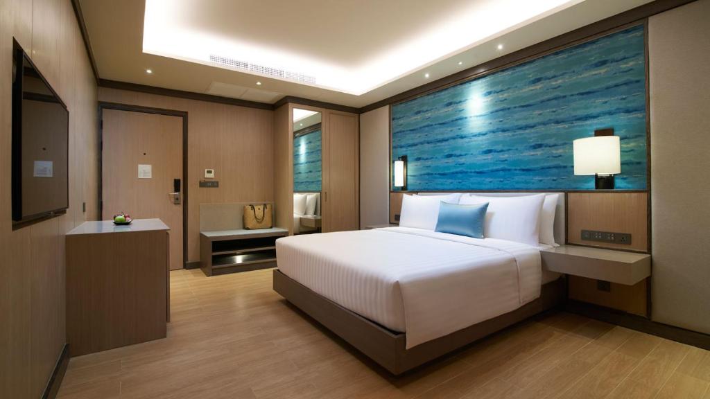a bedroom with a bed and a large painting on the wall at Amari Vogue Krabi in Tab Kaek Beach