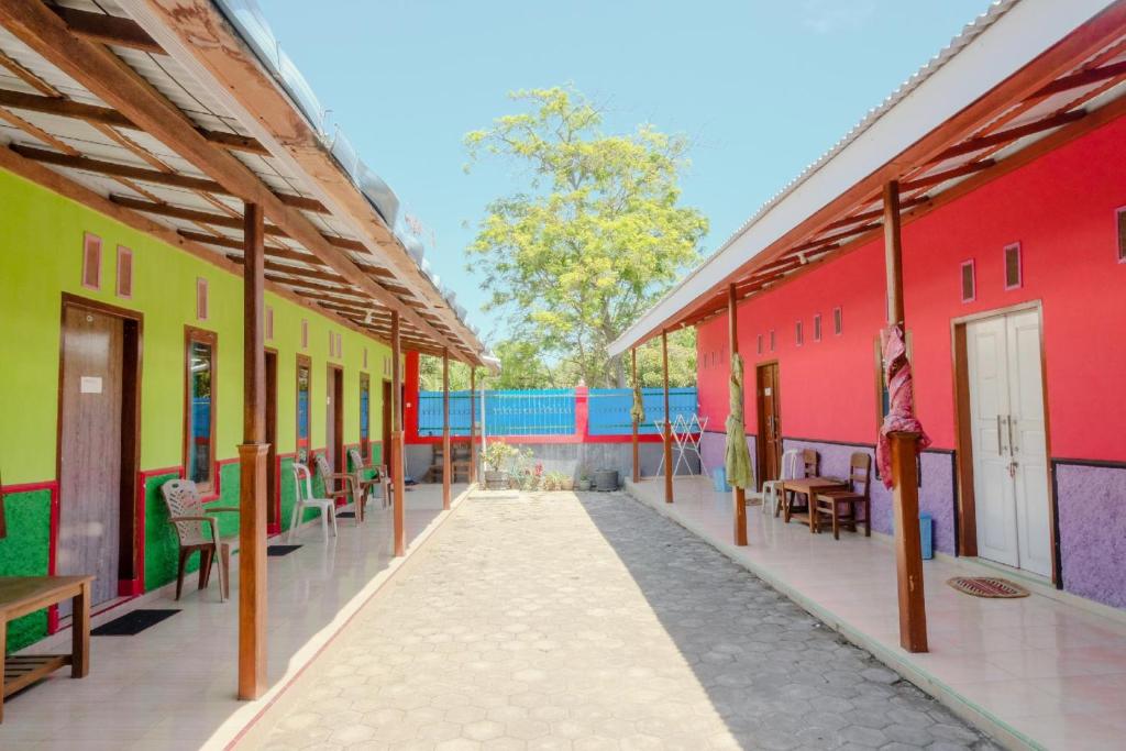 a row of colorful buildings with tables and chairs at Ijen Traveller & Homestay in Banyuwangi