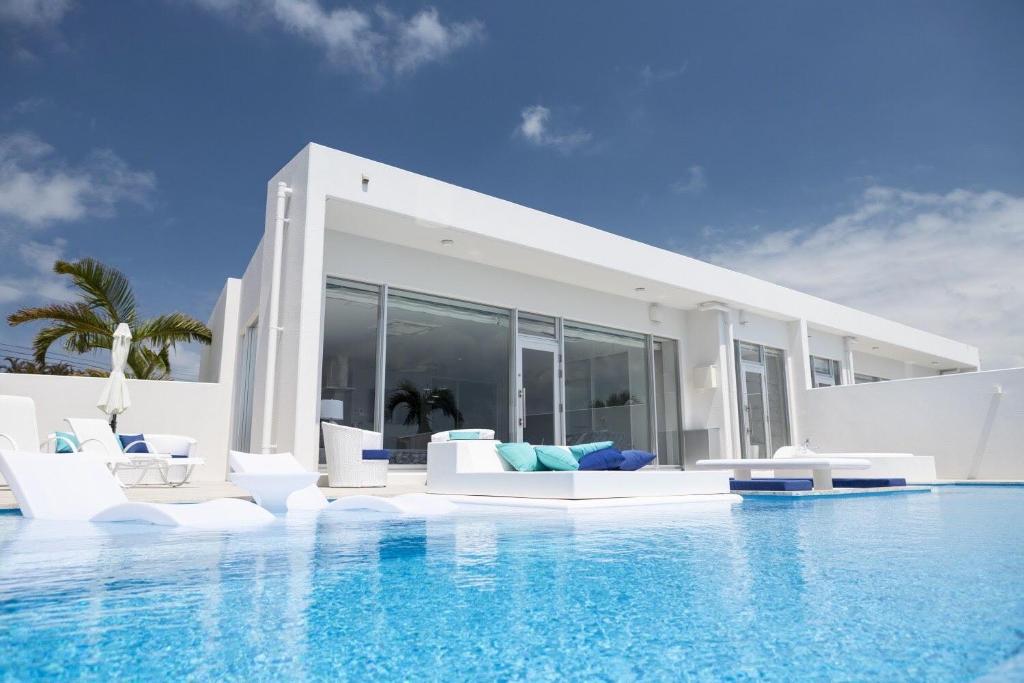 eine Villa mit einem Pool vor einem Haus in der Unterkunft Ronsard Resort IRABU in Miyako-jima