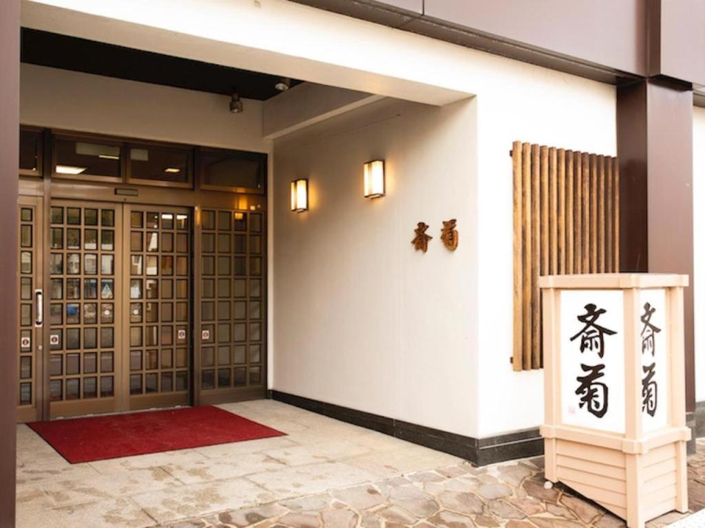 una entrada a un edificio con escritura asiática en la pared en Saigiku, en Iwaki