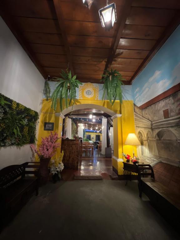 una stanza con una parete gialla con delle palme sopra di Hotel San Sebastián a Antigua Guatemala