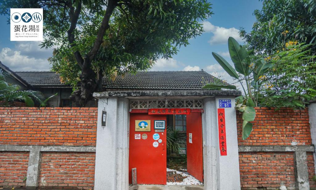 高雄市にある蛋花湯眷村民宿のレンガ造りの建物内の赤と白の扉