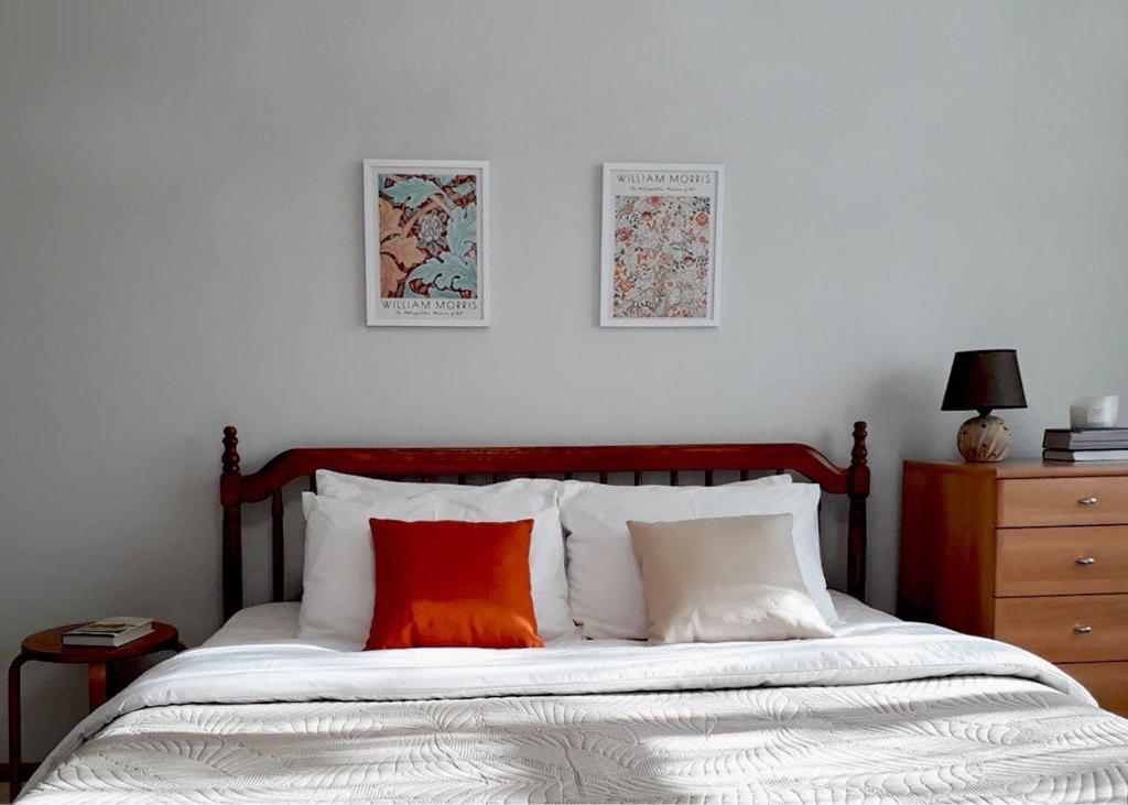 ペトロパブロフスク・カムチャツキーにあるApartment on Prospekt Karla Marksa 11のベッドルーム1室(オレンジ色の枕とドレッサー付きのベッド1台付)