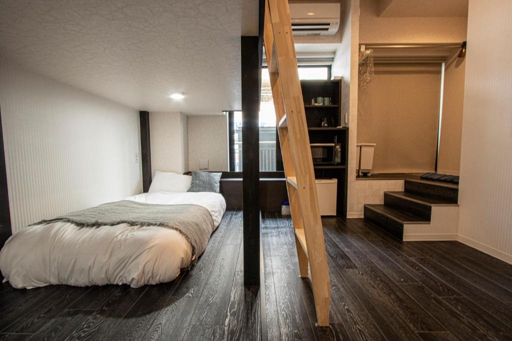 a bedroom with a bed and a staircase in it at GRAND CAVE MOTOMACHI in Yokohama