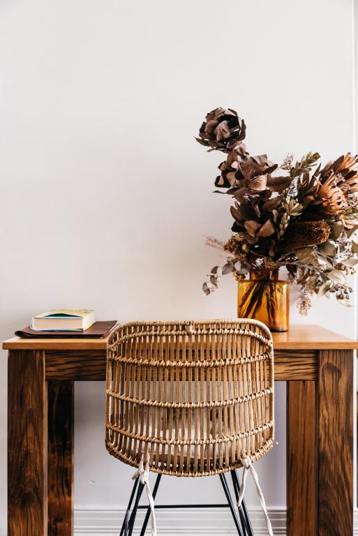 a wicker chair sitting in front of a wooden table at Anchor Geelong in Geelong