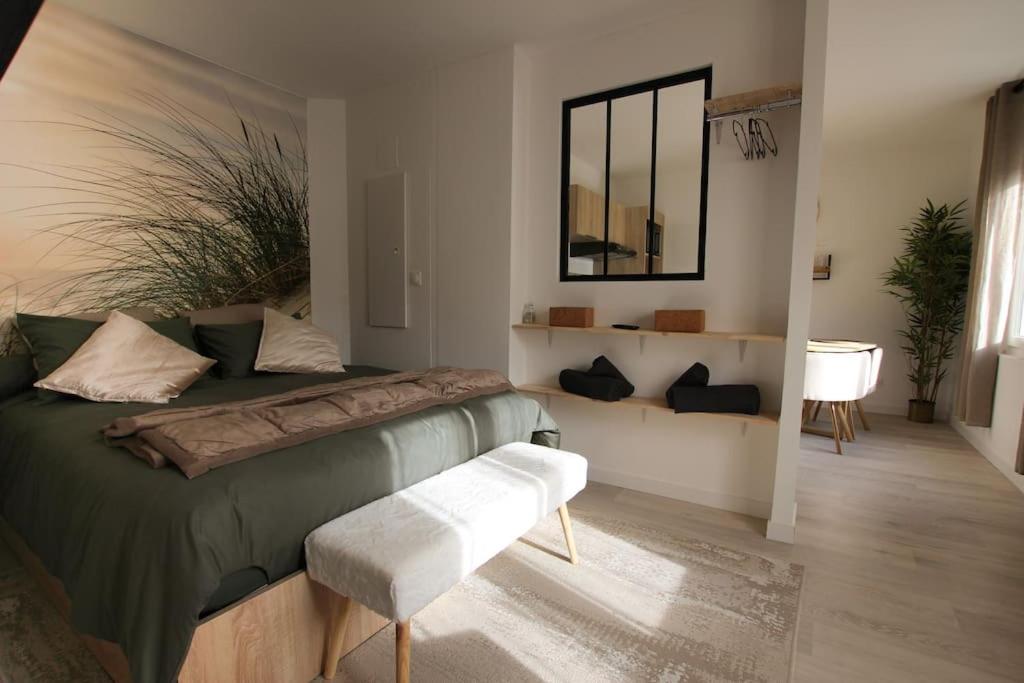 a bedroom with a green bed and a mirror at Appart neuf, parfaitement situé 6min CV-8min GARE in Arles
