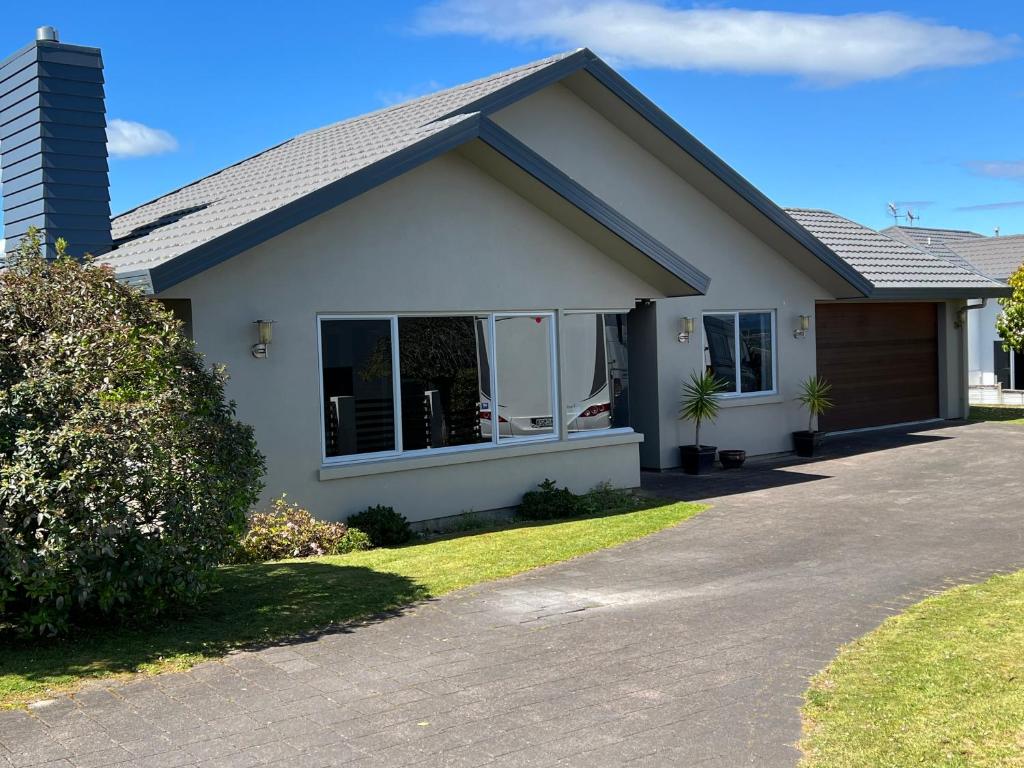 a white house with a driveway at Large stand alone home with two living areas. in Taupo