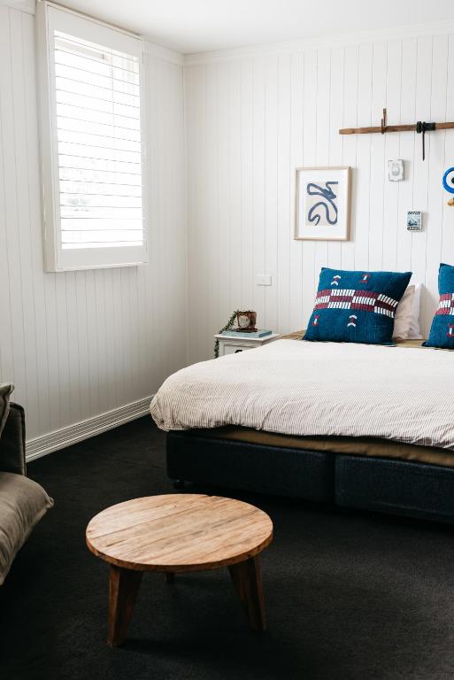 a bedroom with a bed and a wooden stool at Anchor Geelong in Geelong