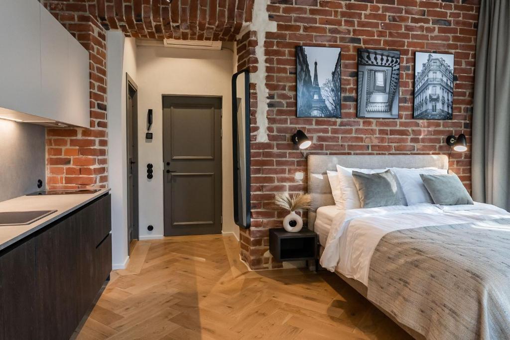 a brick walled bedroom with a bed and a kitchen at N48 Boutique Hotel in Tallinn