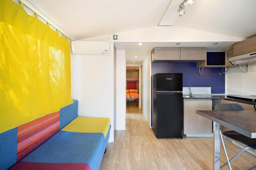 a room with a colorful couch and a kitchen at Camping Grande Italia Vulcano 7 in Chioggia