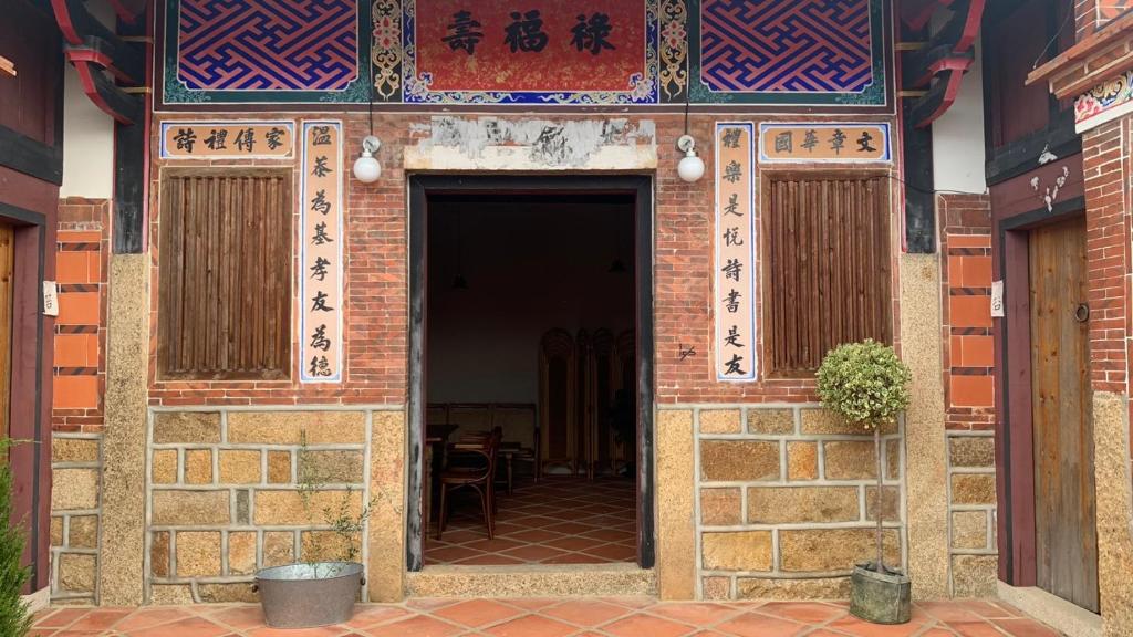 einen Eingang zu einem Backsteingebäude mit einer Tür in der Unterkunft Yamaharuka in Jinhu
