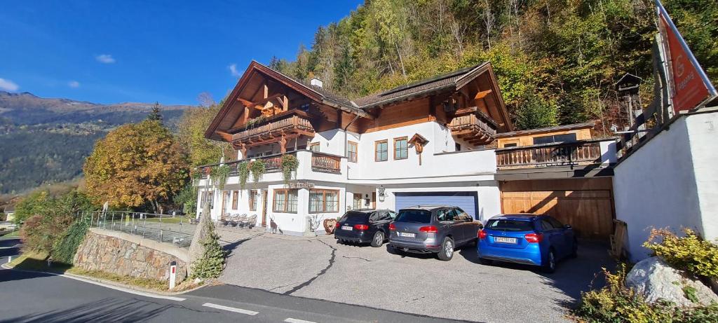 a house with two cars parked in front of it at Appartement Gugganig in Flattach