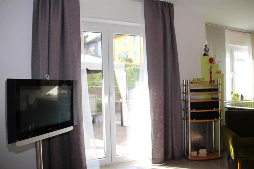 a living room with a tv and a sliding glass door at Ferienwohnung Grete in Merzig
