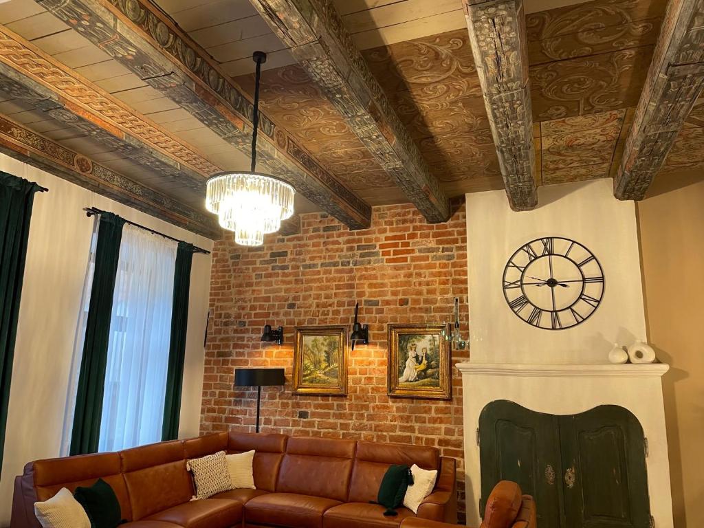 a living room with a couch and a clock on the wall at Apartamenty Żeglarska 25 in Toruń