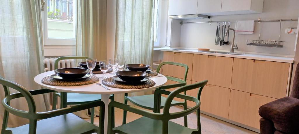 een keuken met een tafel met kommen en wijnglazen bij Brixia Gallery Home in Brescia