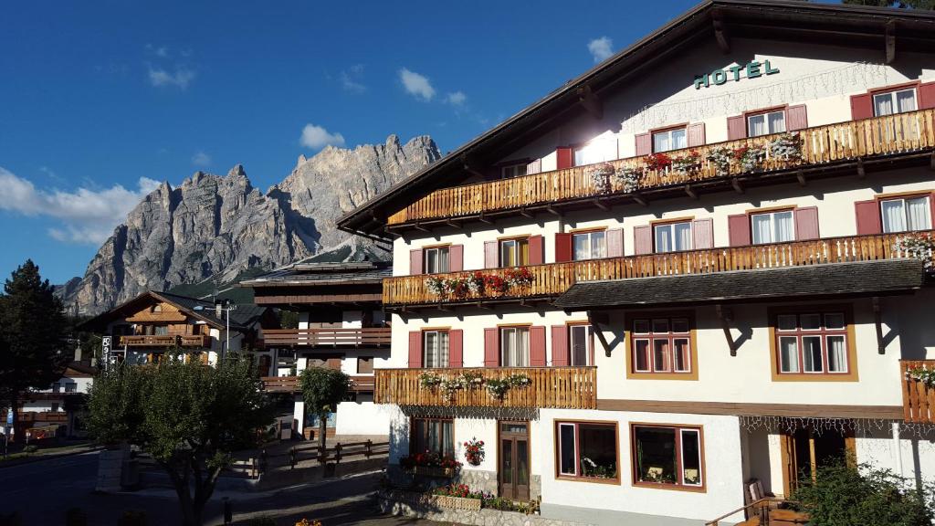 コルティーナ・ダンペッツォにあるHotel Bellaria - Cortina d'Ampezzoの山の上に木製バルコニー付きの大きな建物