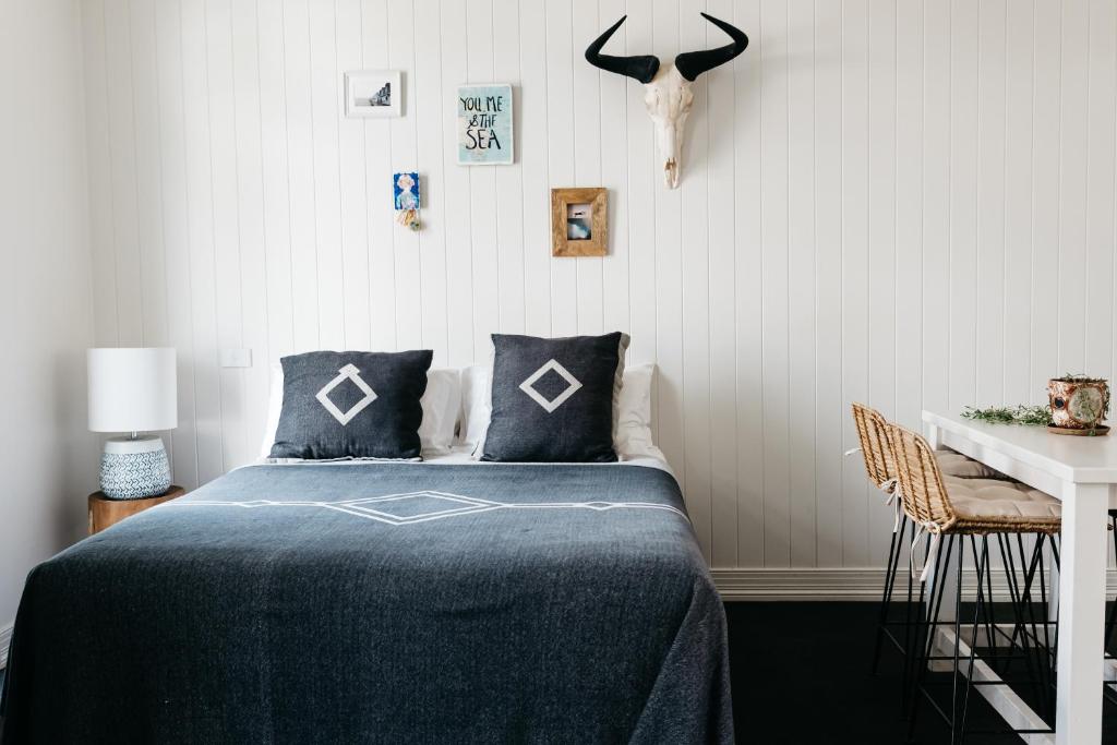 a bedroom with a bed and a table and a skull on the wall at Anchor Geelong in Geelong
