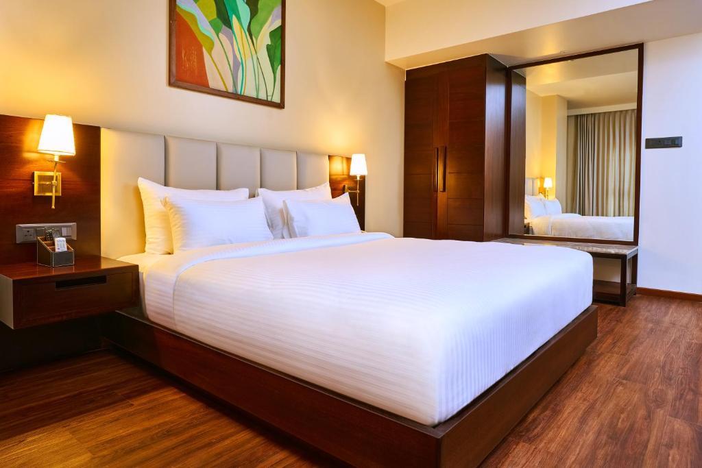 a large white bed in a hotel room at Visthara Hotel in Bengaluru