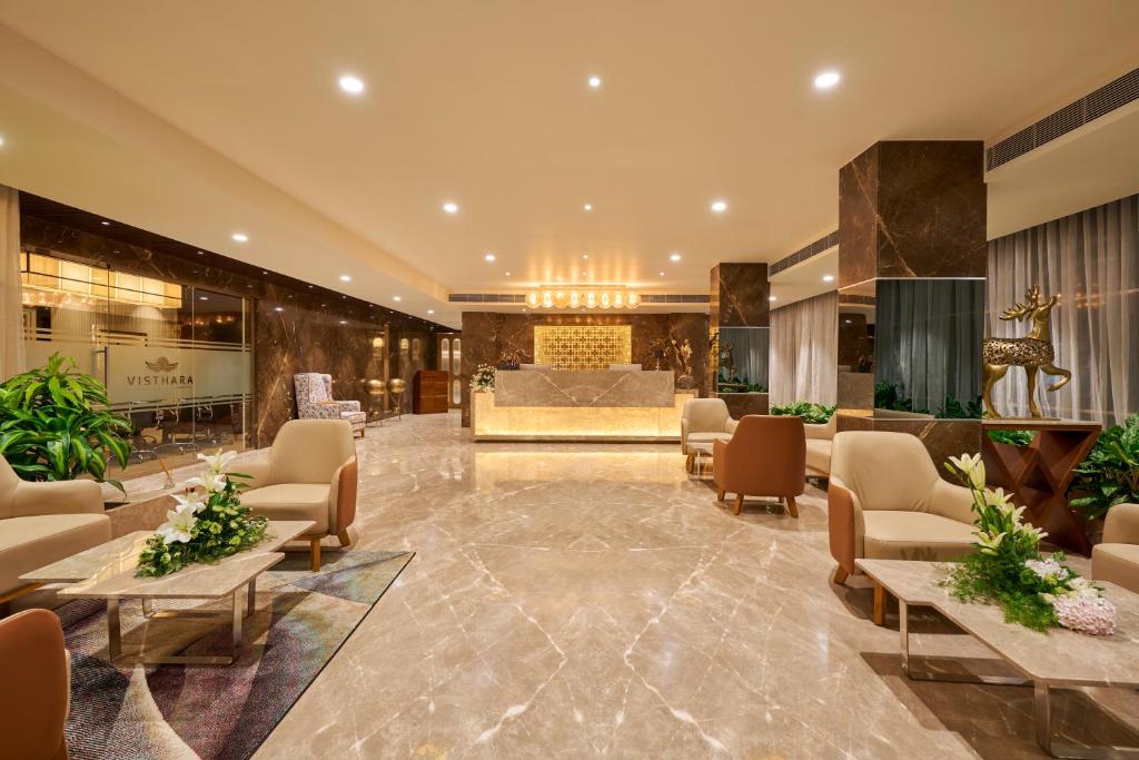 a lobby of a hotel with chairs and a reception at Visthara Hotel in Bengaluru